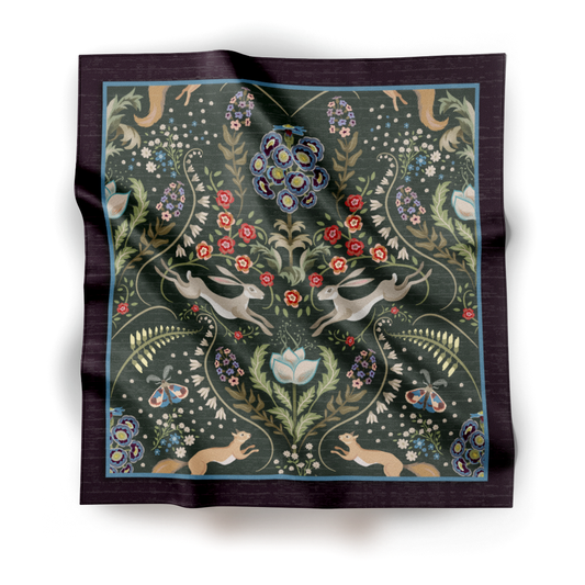 A square silk scarf featuring a detailed garden illustration with flowers, rabbits, and squirrels on a deep green ground, displayed flat against a white background.