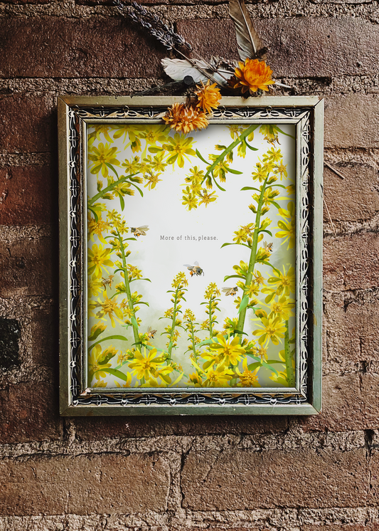 More of This, Please. framed botanical art print by Sue Krizman displayed on a brick wall with dried flowers and a feather